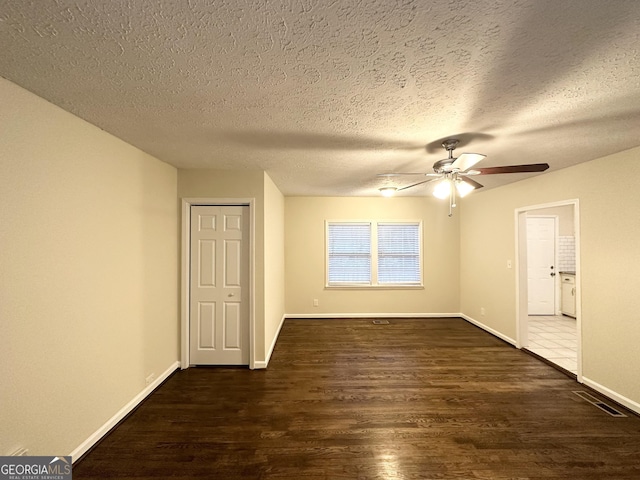 spare room featuring a textured ceiling, dark hardwood / wood-style floors, and ceiling fan