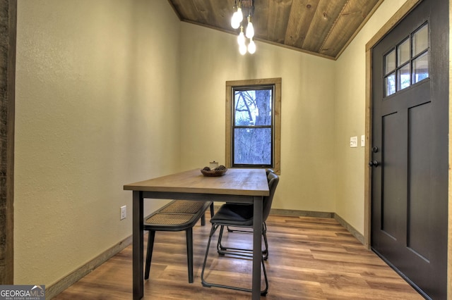 dining space featuring light hardwood / wood-style flooring, a wealth of natural light, and wooden ceiling