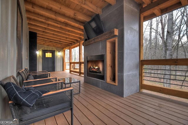 wooden terrace featuring an outdoor fireplace