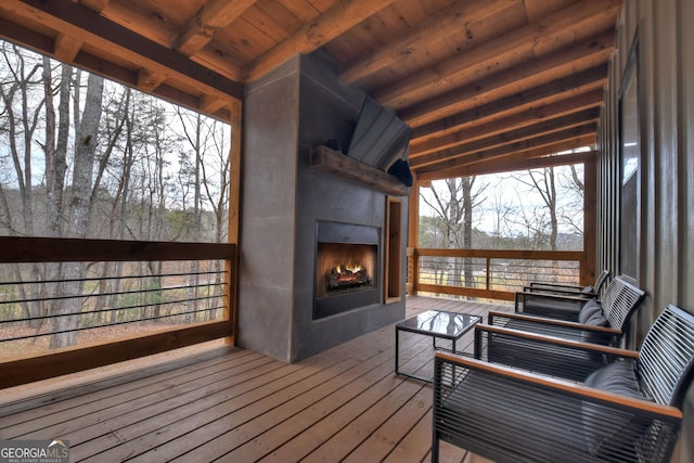 wooden terrace featuring exterior fireplace