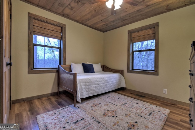 bedroom featuring wood ceiling, ceiling fan, dark hardwood / wood-style flooring, and multiple windows