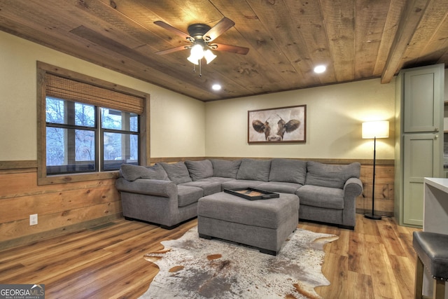 living room featuring wood ceiling, ceiling fan, wooden walls, and light hardwood / wood-style floors