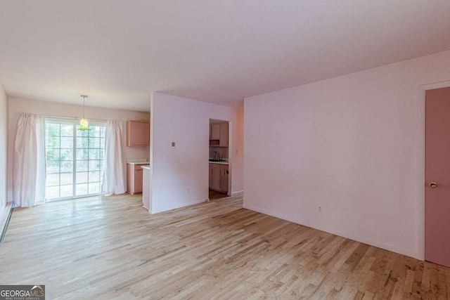 unfurnished living room featuring sink and light wood-type flooring