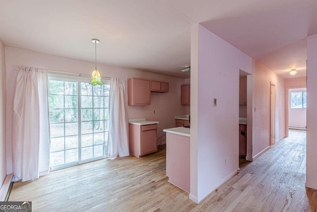 kitchen featuring a baseboard heating unit, light wood-type flooring, and decorative light fixtures