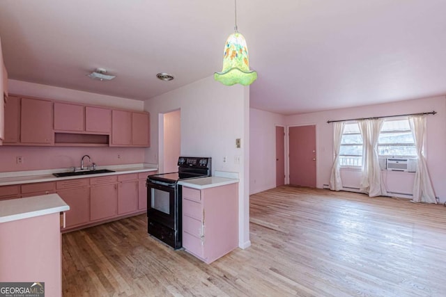 kitchen with sink, light hardwood / wood-style floors, black electric range, and hanging light fixtures