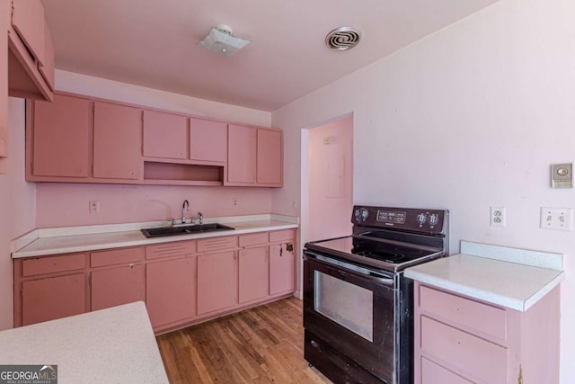 kitchen with sink, hardwood / wood-style floors, and electric range