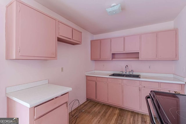 kitchen featuring sink, light hardwood / wood-style floors, and electric stove