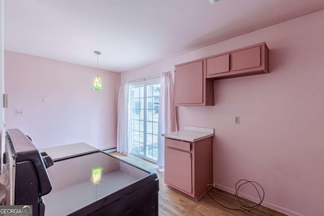 kitchen with range with electric stovetop, hanging light fixtures, and light hardwood / wood-style flooring