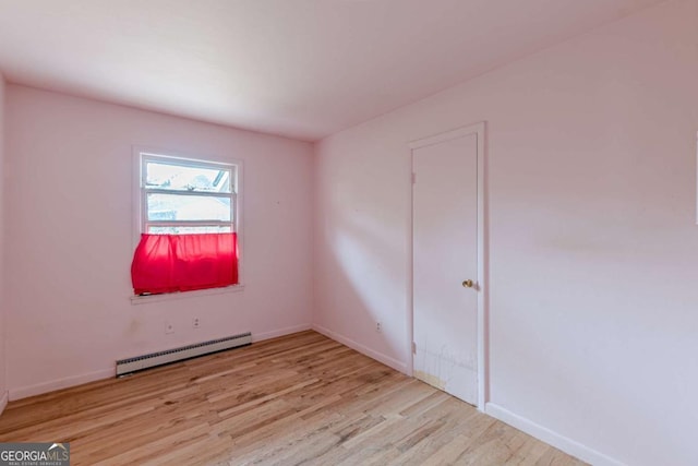 spare room featuring light wood-type flooring and baseboard heating