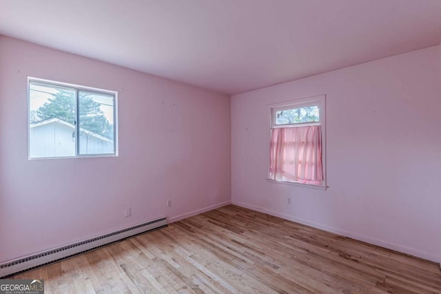 unfurnished room with light hardwood / wood-style flooring and a baseboard radiator