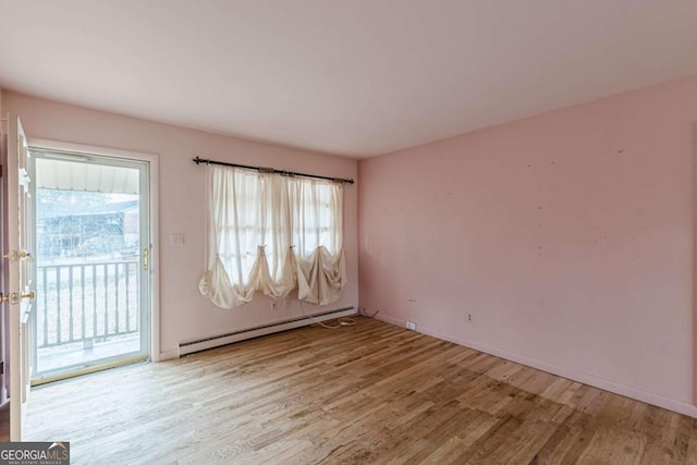 spare room with light wood-type flooring and baseboard heating