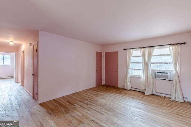 spare room featuring cooling unit and light hardwood / wood-style flooring