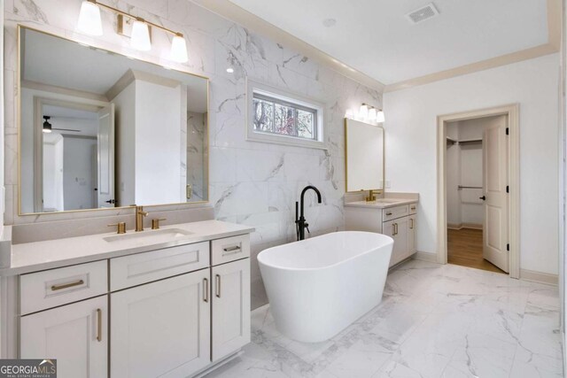 bathroom with vanity, a tub, tile walls, and ceiling fan