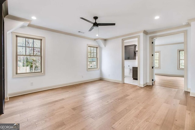 unfurnished living room with crown molding, ceiling fan, and light wood-type flooring