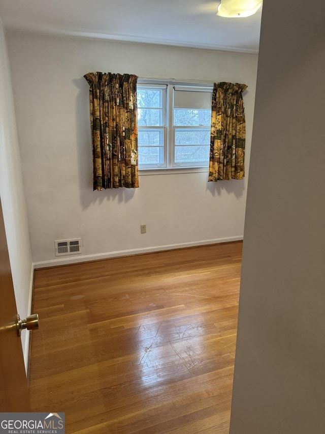 empty room with hardwood / wood-style flooring