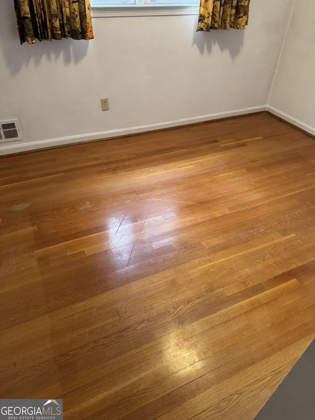 empty room with hardwood / wood-style floors