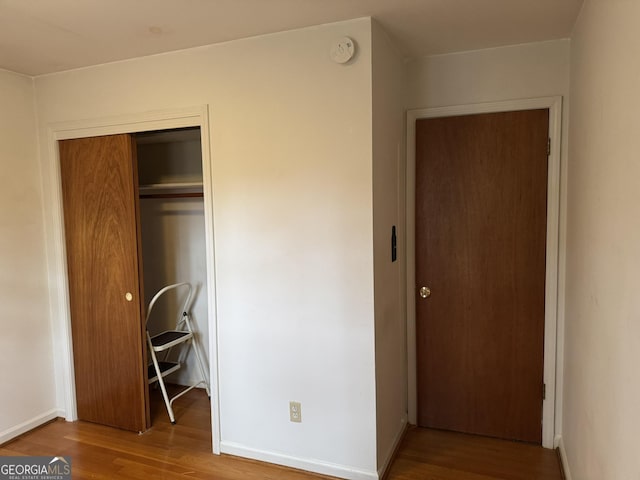 unfurnished bedroom featuring hardwood / wood-style flooring and a closet