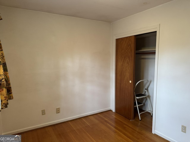 unfurnished bedroom with hardwood / wood-style floors and a closet