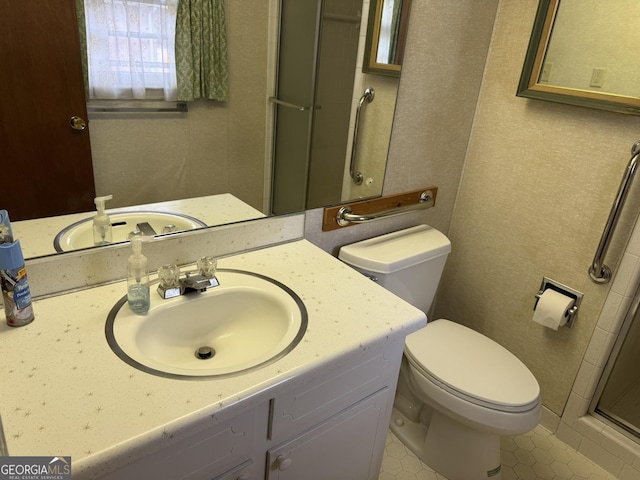 bathroom with a shower with door, vanity, and toilet