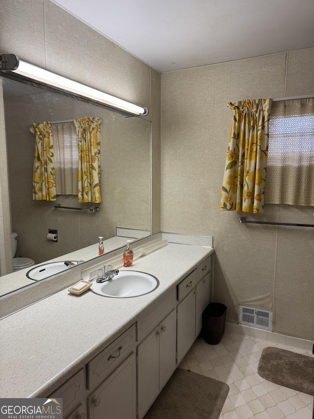 bathroom featuring tile patterned floors, vanity, and toilet