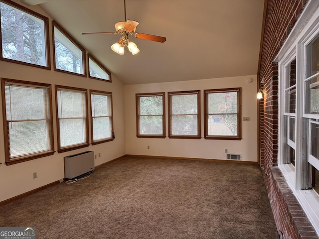 empty room featuring dark colored carpet, radiator heating unit, ceiling fan, and high vaulted ceiling