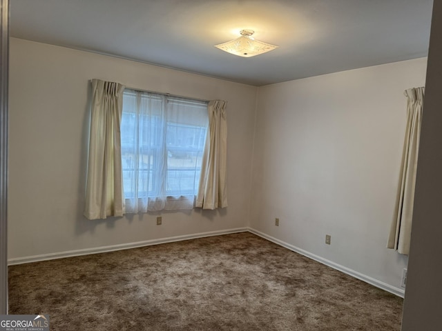 unfurnished room with dark carpet