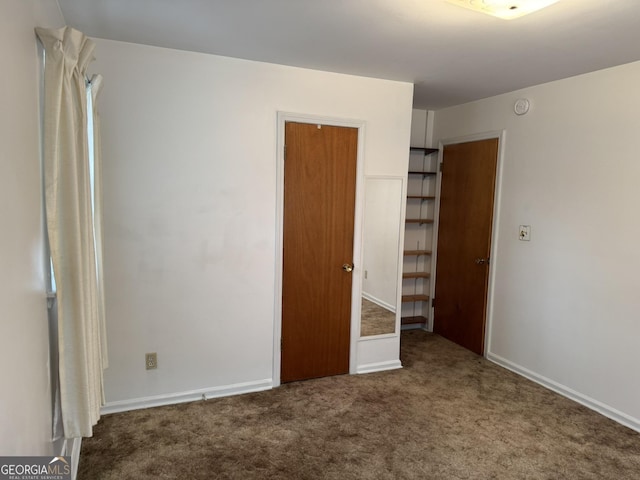 unfurnished bedroom with dark colored carpet