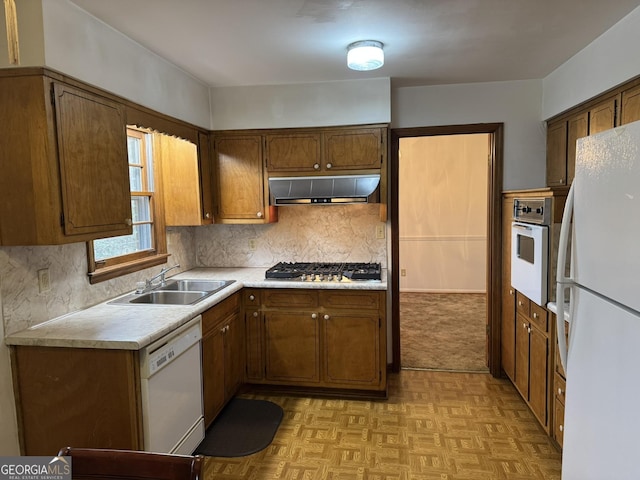 kitchen featuring tasteful backsplash, white appliances, sink, and light parquet floors