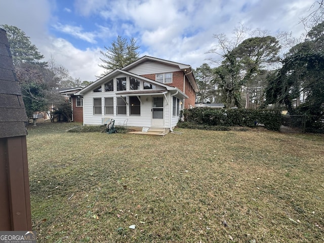 rear view of house featuring a lawn