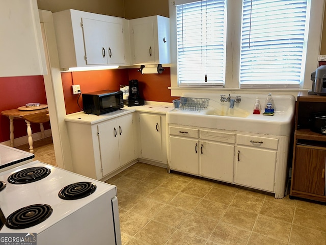 kitchen featuring white range with electric cooktop and white cabinets