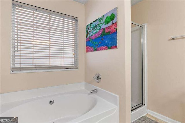 bathroom featuring plenty of natural light and shower with separate bathtub