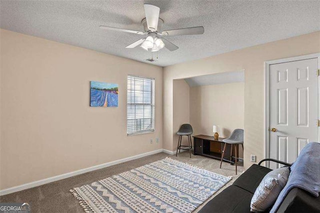 interior space with ceiling fan, a textured ceiling, and carpet