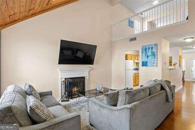 living room featuring wood ceiling, hardwood / wood-style flooring, and high vaulted ceiling