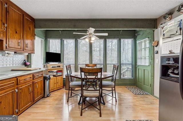 kitchen featuring ceiling fan, a textured ceiling, light wood-type flooring, and decorative backsplash