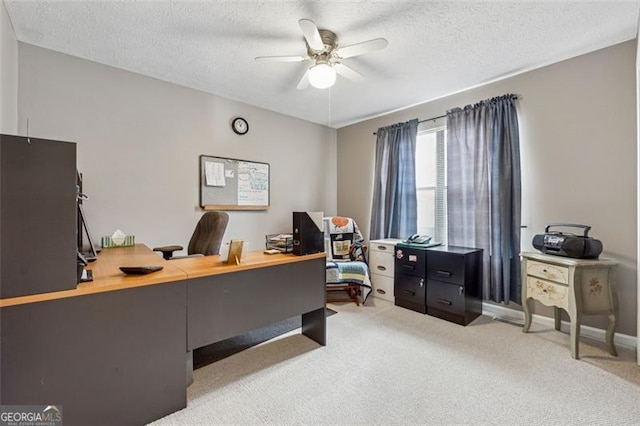 carpeted office with a textured ceiling and ceiling fan