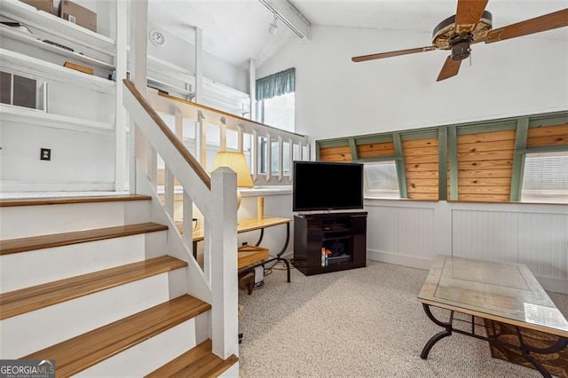 interior space featuring vaulted ceiling with beams, ceiling fan, and carpet flooring