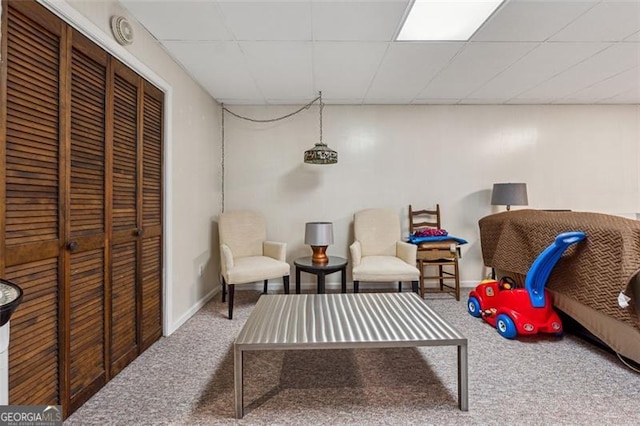 sitting room with carpet floors and a paneled ceiling