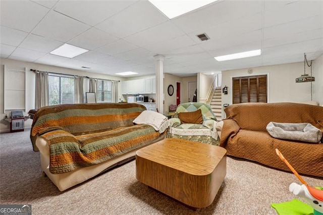 carpeted living room with a drop ceiling