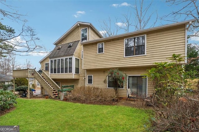 rear view of property featuring a wooden deck and a yard