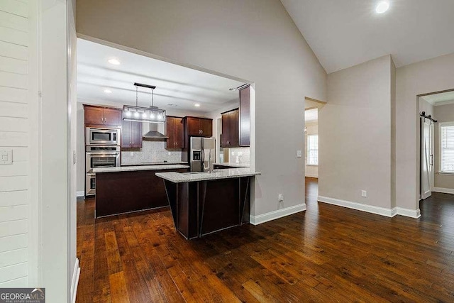 kitchen featuring decorative backsplash, dark wood-style floors, appliances with stainless steel finishes, vaulted ceiling, and pendant lighting