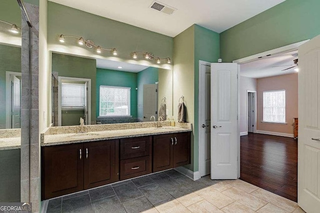 full bathroom with visible vents, a sink, baseboards, and double vanity