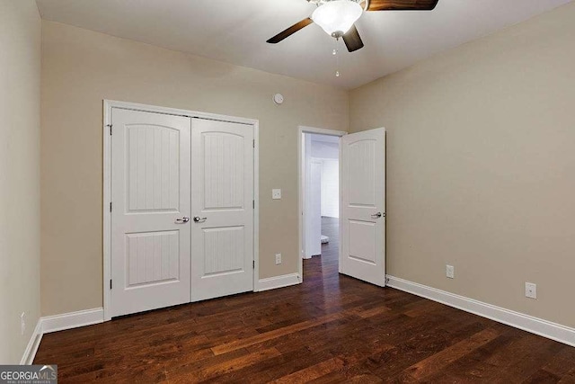 unfurnished bedroom with ceiling fan, baseboards, dark wood finished floors, and a closet