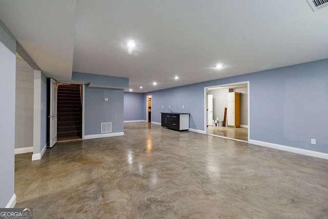 unfurnished living room featuring stairs, recessed lighting, visible vents, and finished concrete floors