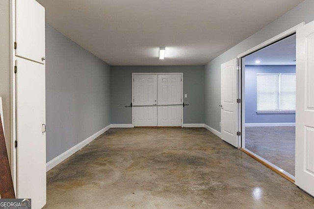 interior space featuring concrete flooring and baseboards