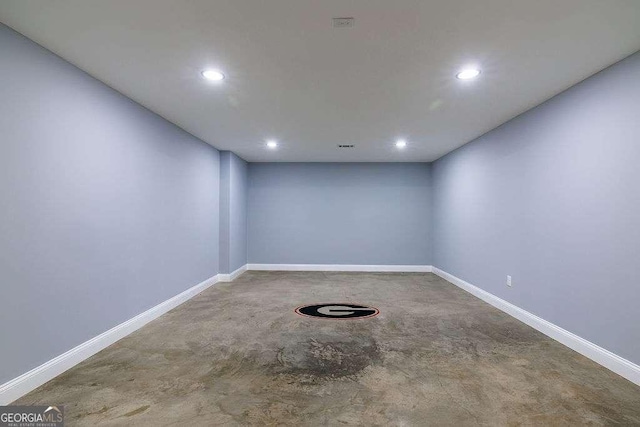 unfurnished room featuring concrete floors, baseboards, and recessed lighting