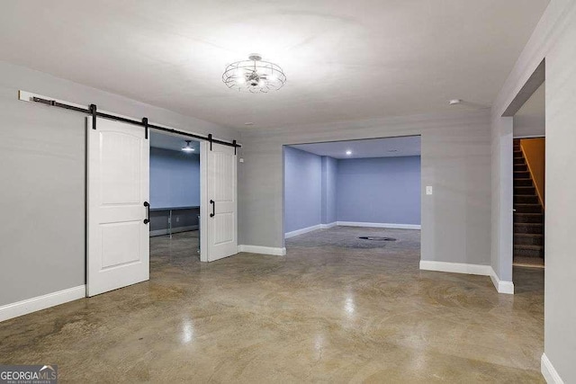 interior space featuring stairs, finished concrete flooring, baseboards, and a barn door