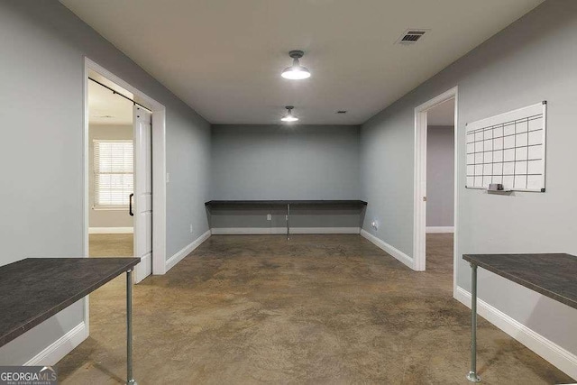 interior space with finished concrete floors, visible vents, and baseboards