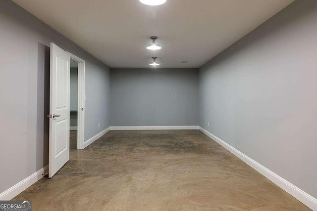 unfurnished room featuring finished concrete floors and baseboards