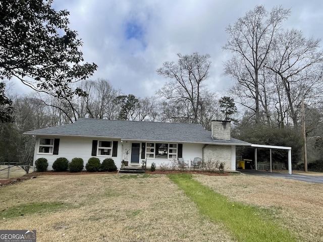 ranch-style home with a front yard and a carport