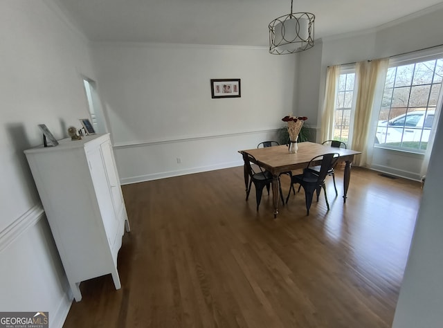 dining area with ornamental molding and dark hardwood / wood-style floors